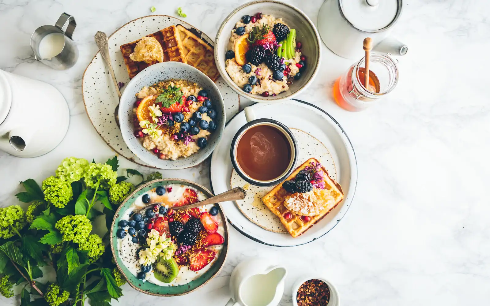 A brunch table shot from directly overhead on marble — berry bowls, waffles with honeycomb, coffee and flowers, the standard styled flat-lay of a Xiaohongshu note